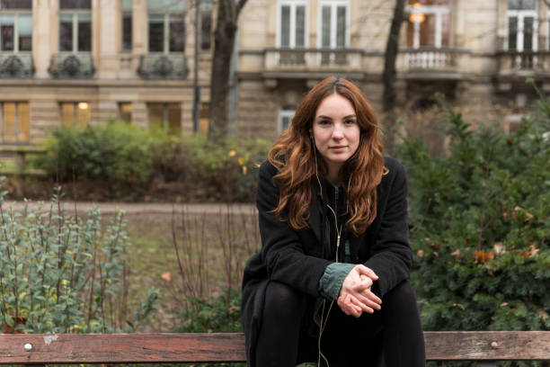 istock Young Caucasian Woman Sitting on Park Bench Backrest 1223655280