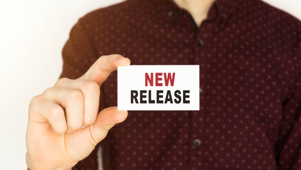 istock Businessman holding a card with text NEW RELEASE. 1223655625