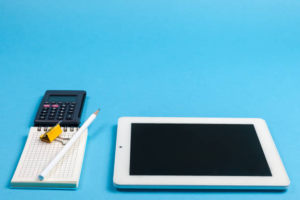 istock workspace top view. office Desk with office supplies, calculator and computer. side view blue background 1223656862