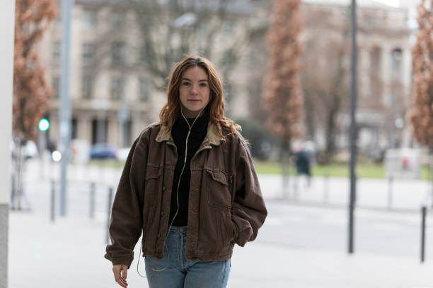istock Young Woman with Hand in Jacket Pocket Looking at Camera 1223657174