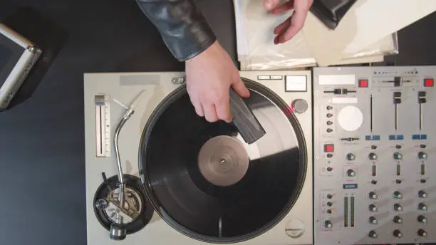 Photo of The musician brushes a vinyl record. Top view