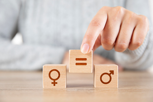 Female hand putting equal symbol between men and woman icons