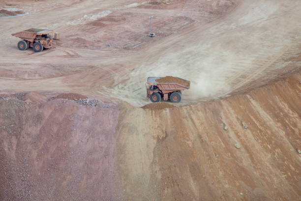 istock Two dump trucks from above looking down on dirt landscape 1223662094