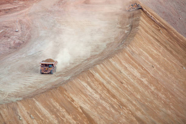 istock Large dump truck stirs up dust hauling dirt in strip mining operation 1223662099