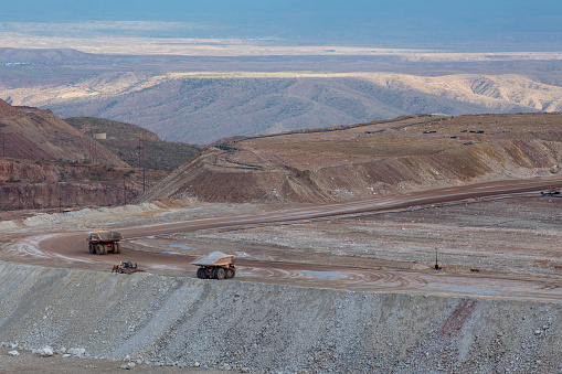 Dump trucks haul earth from strip mine operation in remote area in Morenci, AZ, United States