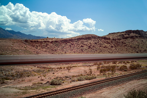 Train blurred in motion moving through desert canyon railroad tracks in Kingman, AZ, United States