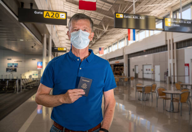 старший мужчина в маске для лица в качестве защиты от вируса в аэропорту - passport old usa id card стоковые фото и изображения