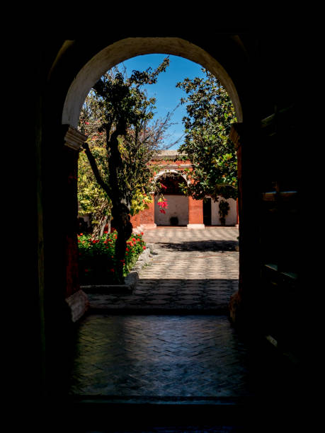수도원 수도원 데 산타 카탈리나에있는 식민지 파티오 입구의 수직 사진. 유명한 빨간 아케이드와 녹색 식물이있는 안뜰. 이미지에 사람이 없습니다. - peru arequipa monastery convent 뉴스 사진 이미지