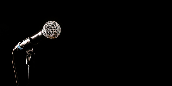 Dynamic microphone on stand isolated on black background.