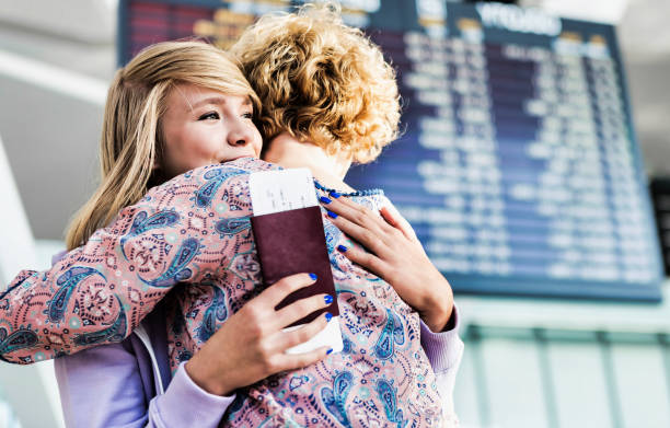 Young teenage girl reuniting with her mother in airport Young teenage girl reuniting with her mother in airport airport hug stock pictures, royalty-free photos & images