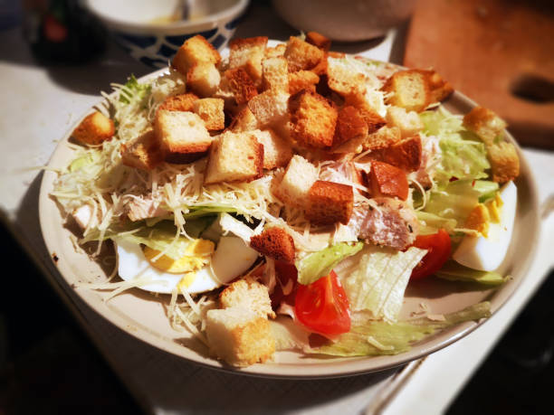 istock Caesar salad is cooked at home and laid out on a large beige plate. 1223670256