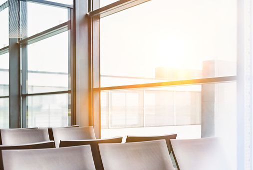 Photo of empty chairs on airport gate with lens flare