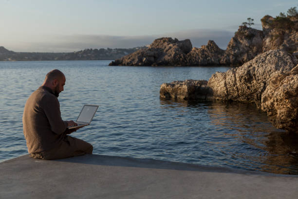istock A young man using the laptop at sunrise . 1223674117