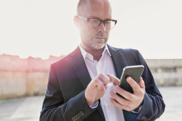 istock Portrait of businessman using smartphone while leaning on wall 1223675621