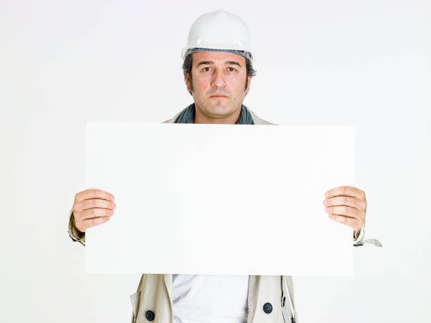 istock Smiling male architect holding the blank banner on white background. 1223678413