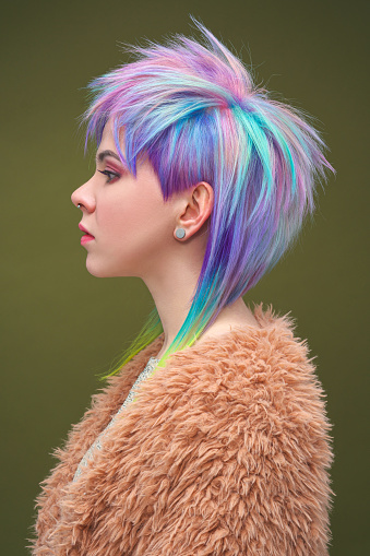 Portrait of a beautiful young girl with dyed colored hair. Hairstyle and makeup. Fashion shooting for the hairdresser colorist. Rainbow hair.