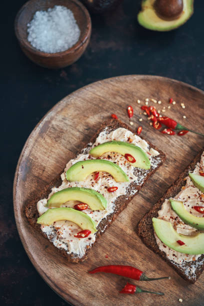 istock Preparing Avocado Sandwich with Brown Bread, Cottage Cheese and Chili 1223681136