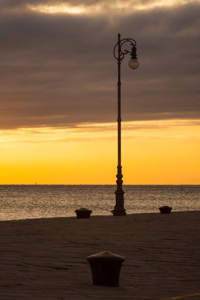 istock Street lamp at sunset next to the Trieste sea 1223682483