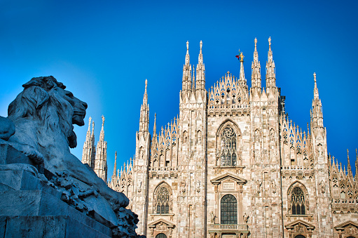 The golden sunshine is reflecting on the front of the magnificent Duomo di Milano or Milan Cathedral after Italy eases coronavirus restrictions after two month lockdown