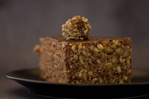 istock Black Plate With Slice Of Chocolate Cake With Nuts 1223687091