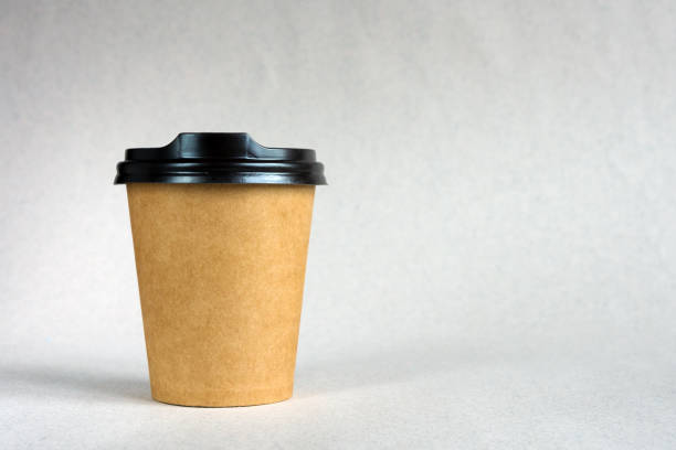istock Disposable paper cups for coffee on a beige background. 1223687118