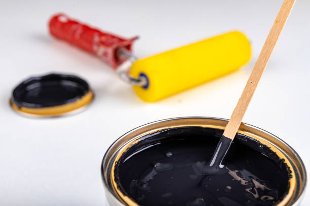 istock Black paint can and paint roller. Paint application accessories. Light background. 1223687274