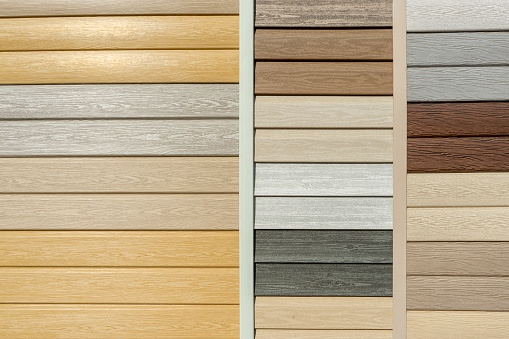 Vinyl siding with imitation wood texture in bright palette of colors. Plastic wall covering for exterior decoration of house. Abstract background for your design with copy space and place for text.