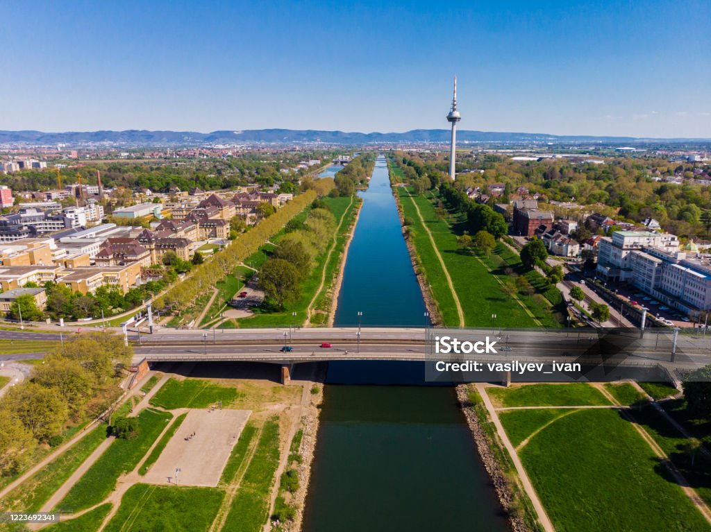 Top view of the embankment of the Neckar River. Bridges, TV tower, green grass and trees. Hospital, tram lines. Mannheim. Germany. Mannheim Stock Photo