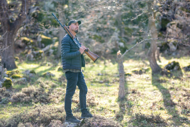 istock a man in the woods with hunter gun 1223693641