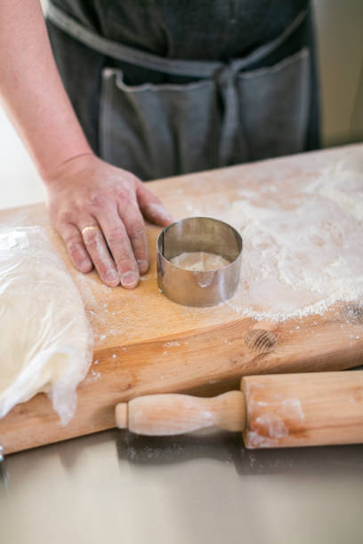 istock Crop chef working with dough. Faceless man at steel table with wooden board 1223693902