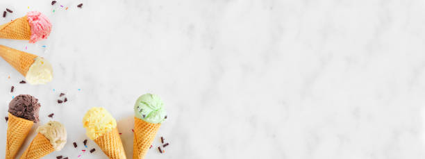 bordure de cône de crème glacée avec une variété de saveurs, vue supérieure sur un fond blanc de bannière de marbre - coin chocolate food chocolate coin photos et images de collection