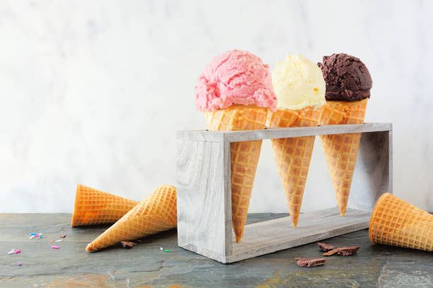 istock Ice cream cone table scene against marble, strawberry, vanilla and chocolate flavors 1223696875