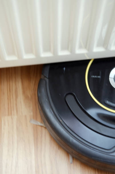 istock robotic vacuum cleaner stuck between floor and radiator 1223697063