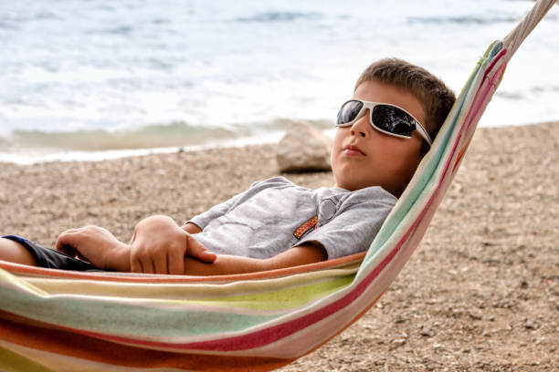 istock The boy is chafing away on a hammock by the sea. 1223697819