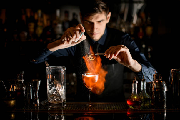 istock Bartender at the bar burns slice of citrus and sprinkles on it. 1223698195