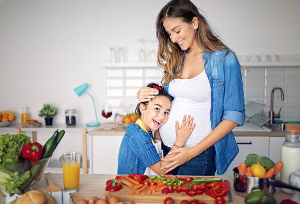 istock Pregnant mother is hugging her daughter in a kitchen 1223698759