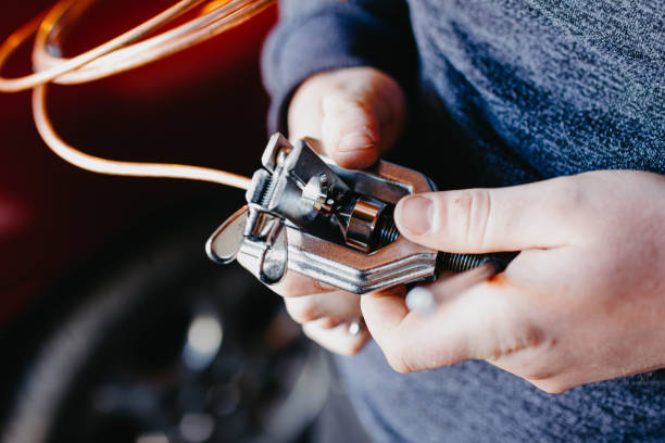 istock rolling and cutting of a copper tube, car brake system, air conditioning, refrigerator. Roller tool in the hands of the master. 1223700013