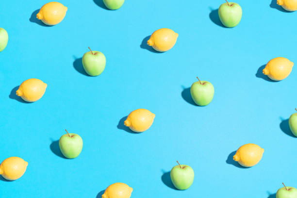 istock Lemon and apple pattern on bright light blue background. Minimal flat lay food texture. Summer abstract trendy fresh concept 1223700997