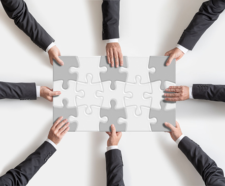 Business successful teamwork concept four business man assembling jigsaw puzzle