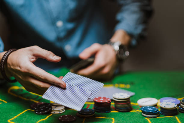 istock Croupier holds playing cards, game chips on the table. 1223703863
