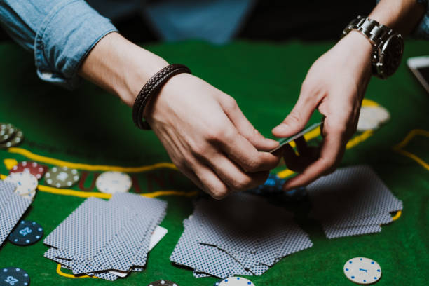 istock Croupier holds playing cards, game chips on the table. 1223703999
