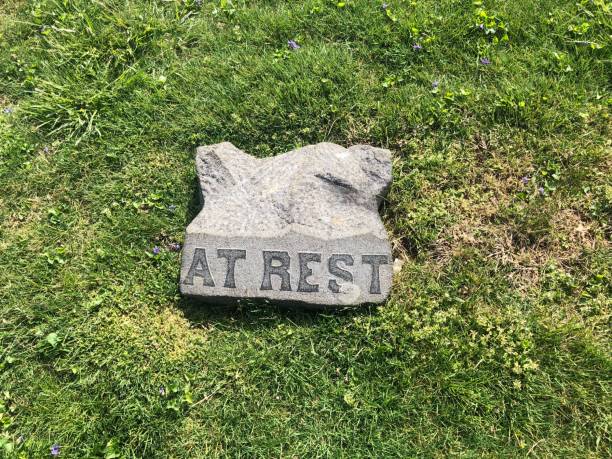 istock Gray Tombstone in Green Grass Marks Grave with: At Rest 1223704168