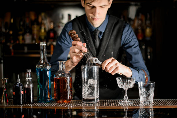 istock Young bartender splits pieces of ice to make a cocktail. 1223704271