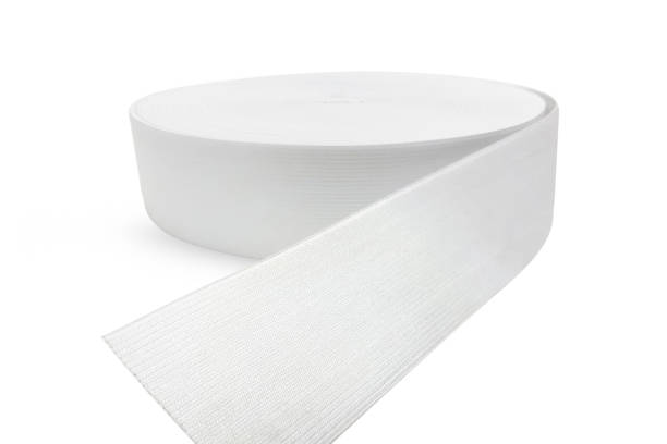 istock Rubber roll. White elastic band roll for sewing close-up. Fabric tape for needlework of the cloth on white background. Cloth ribbon made of polyester fibre for the production of knitwear textile tapes 1223705038