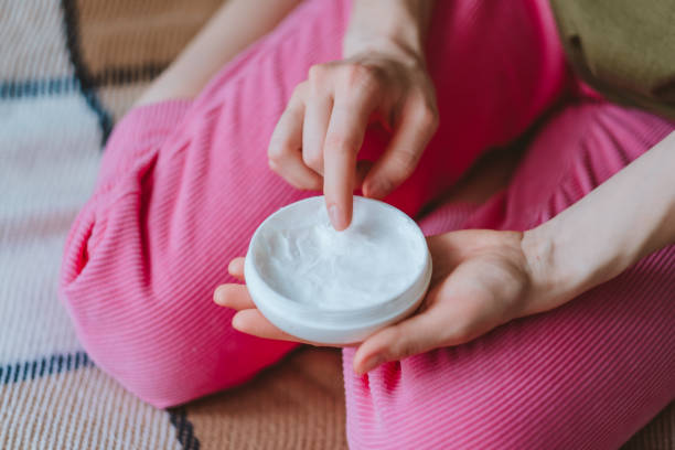 istock Young female uses body cream. 1223705260
