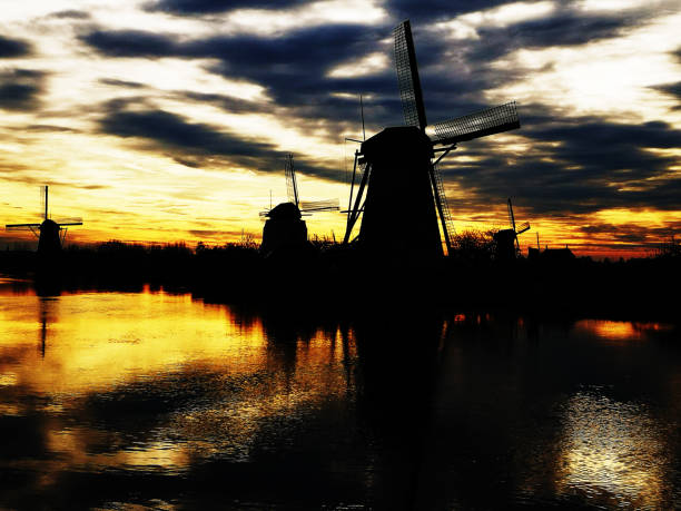 istock Windmills with reflektion beside river in dusk 1223705336