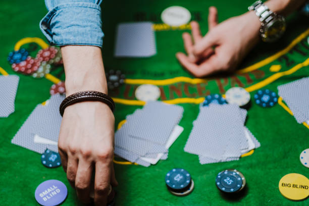 istock Croupier holds playing cards, game chips on the table. 1223706131