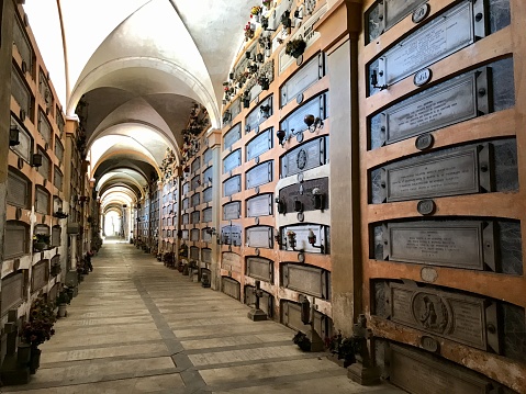 Genoa, Italy - May 17, 2017: Monumental Cemetery of Staglieno is a crisscrossing of large ancient burial niches arcades located on a hillside in the district of Staglieno of Genoa, Italy.