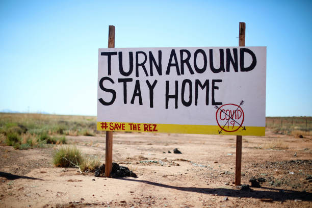COVID-19 stay home sign on Navajo Nation A sign along the road from Leupp to I-40 encourages people in the Navajo Nation to stay at home. COVID-19 hit the nation's rural people particularly hard. May 5, 2020. navajo nation covid stock pictures, royalty-free photos & images
