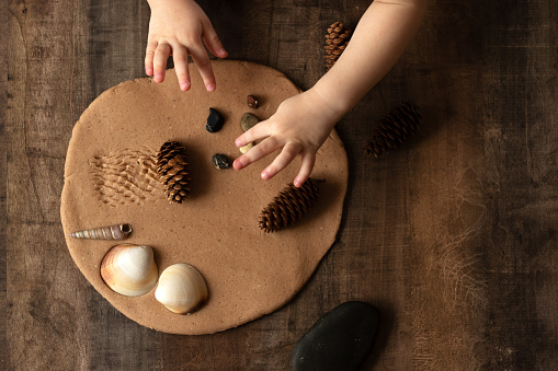 Modeling with salt dough on the kitchen table. Natural materials for the game, the natural composition of the product. Creative development of children in the period of self-isolation.